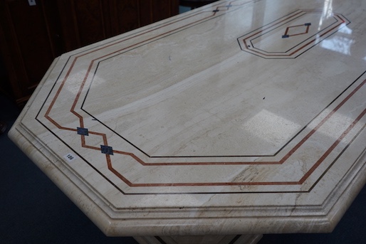 A Travertine marble dining table of elongated octagonal form on twin octagonal column supports, length 260cm, depth 120cm, height 74cm